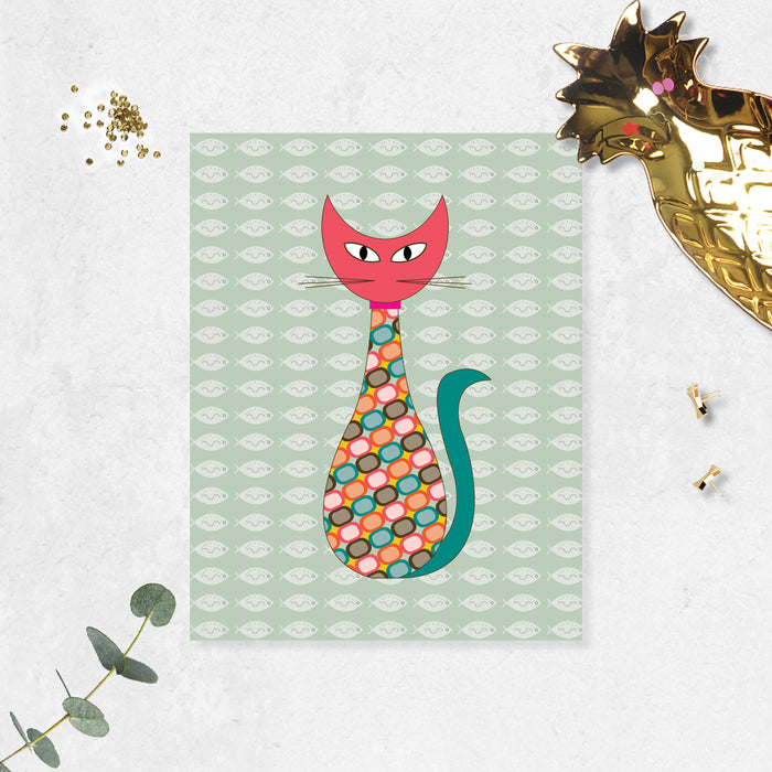 mid century modern cat styled with pink head, green tail and geometric shapes in the body, soft sage green background has shite fishes printed on matte paper