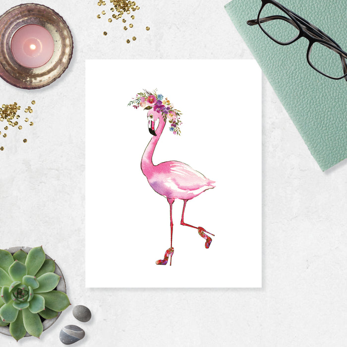 pink flamingo wearing high heels with one leg kicked back her shoes have a floral pattern and her head is adorned with a watercolor floral wreath in shades of pinks purples and blues with greenery on matte white paper