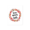 love never fails surrounded by a wreath of pink and coral watercolor flowers with greenery printed on matte white paper