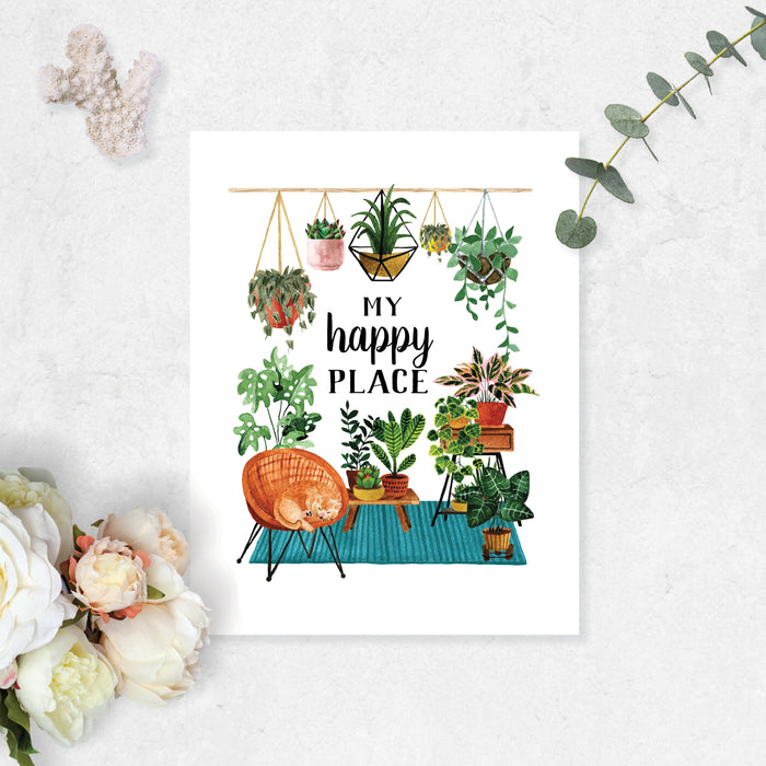 my happy place surrounded by haing plants and plants on a teal blue rug with plant stands and more plants, there is also a wicker chair with a yellow cat curled up sleeping printed on matte white paper